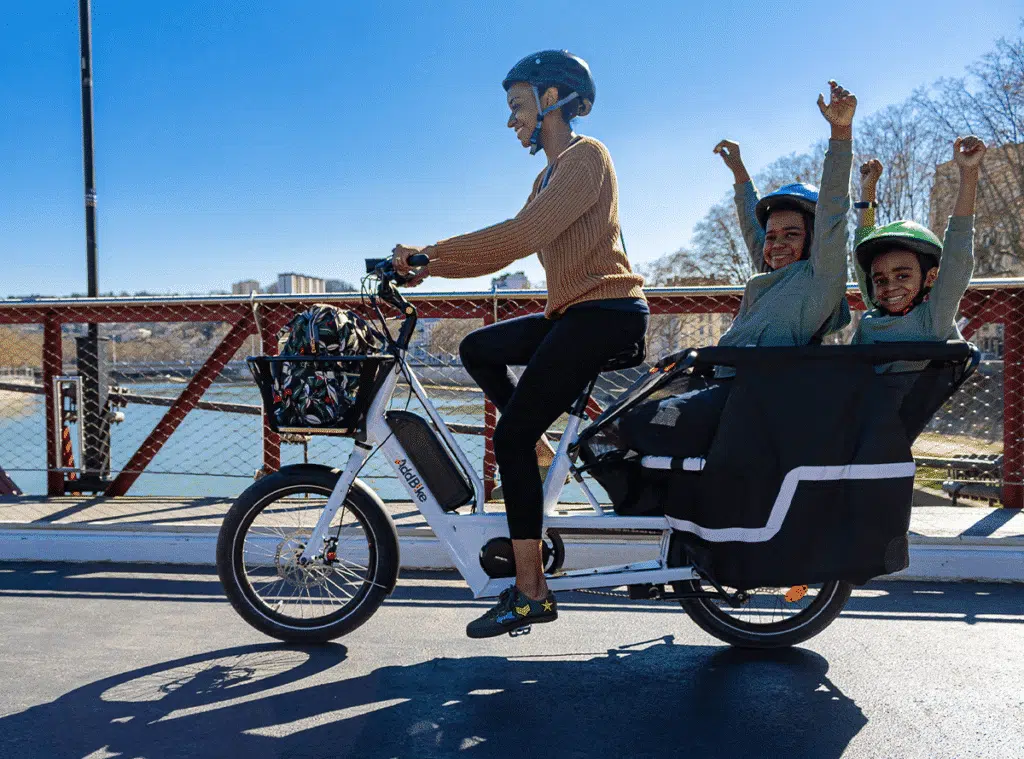 Mum driving in the city with two kids on the cargo E-Bike