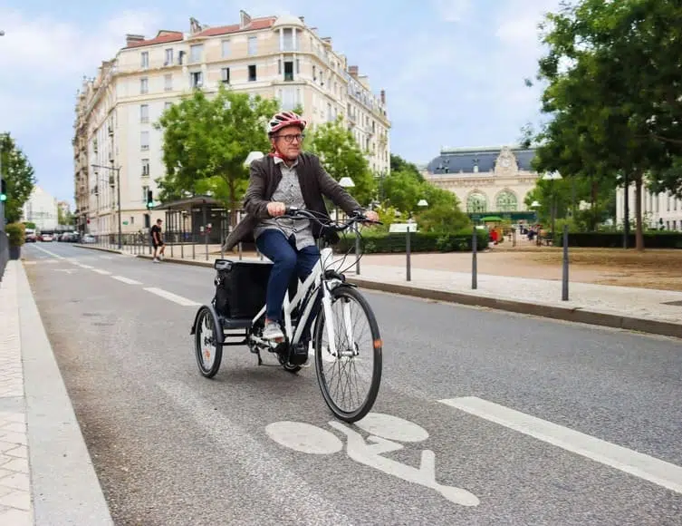 Lastendreirad Elektro: Fahrradfahrer mit Helm im Straßenverkehr