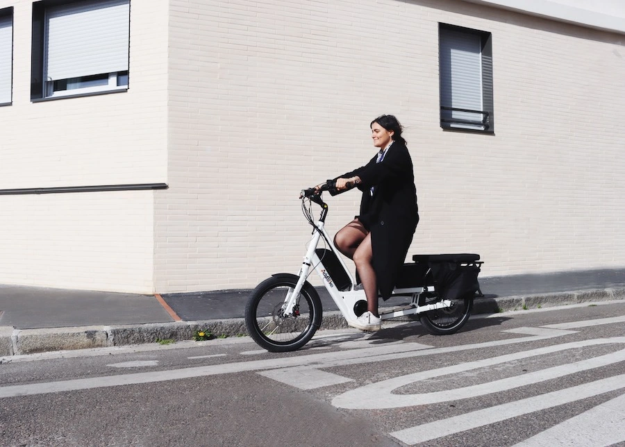 UK cargo bikes: woman riding a white longtail in a city