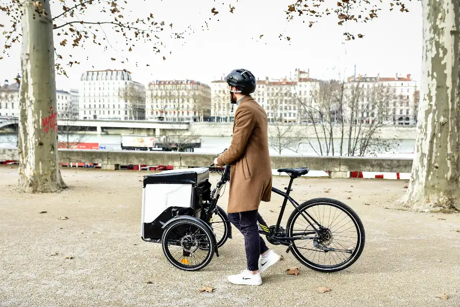 Man walking along a bike with cargo box kit