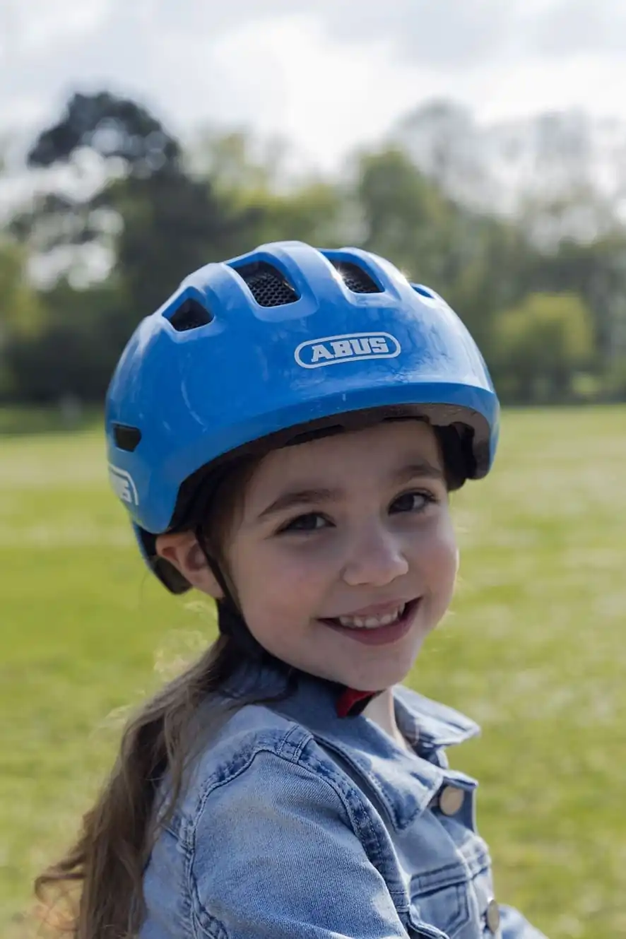Enfant portant un casque sur une carriole velo