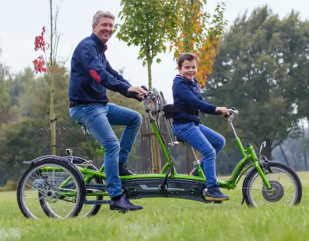 Dad and son with mobility issuesriding a tandem
