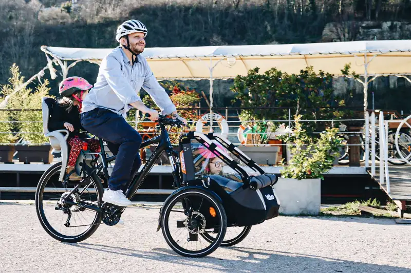 Tricycle for adult: dad riding with two kids a front trike