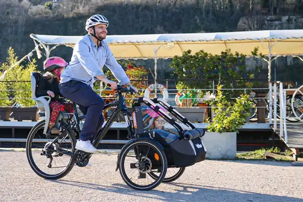 Vélo avec remorque devant : un papa et ses deux filles